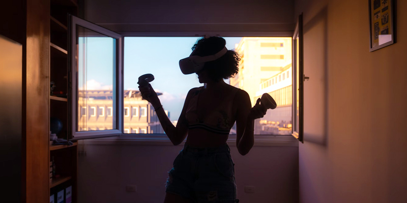 Chica a contraluz utilizando un dispositivo de Realidad Virtual